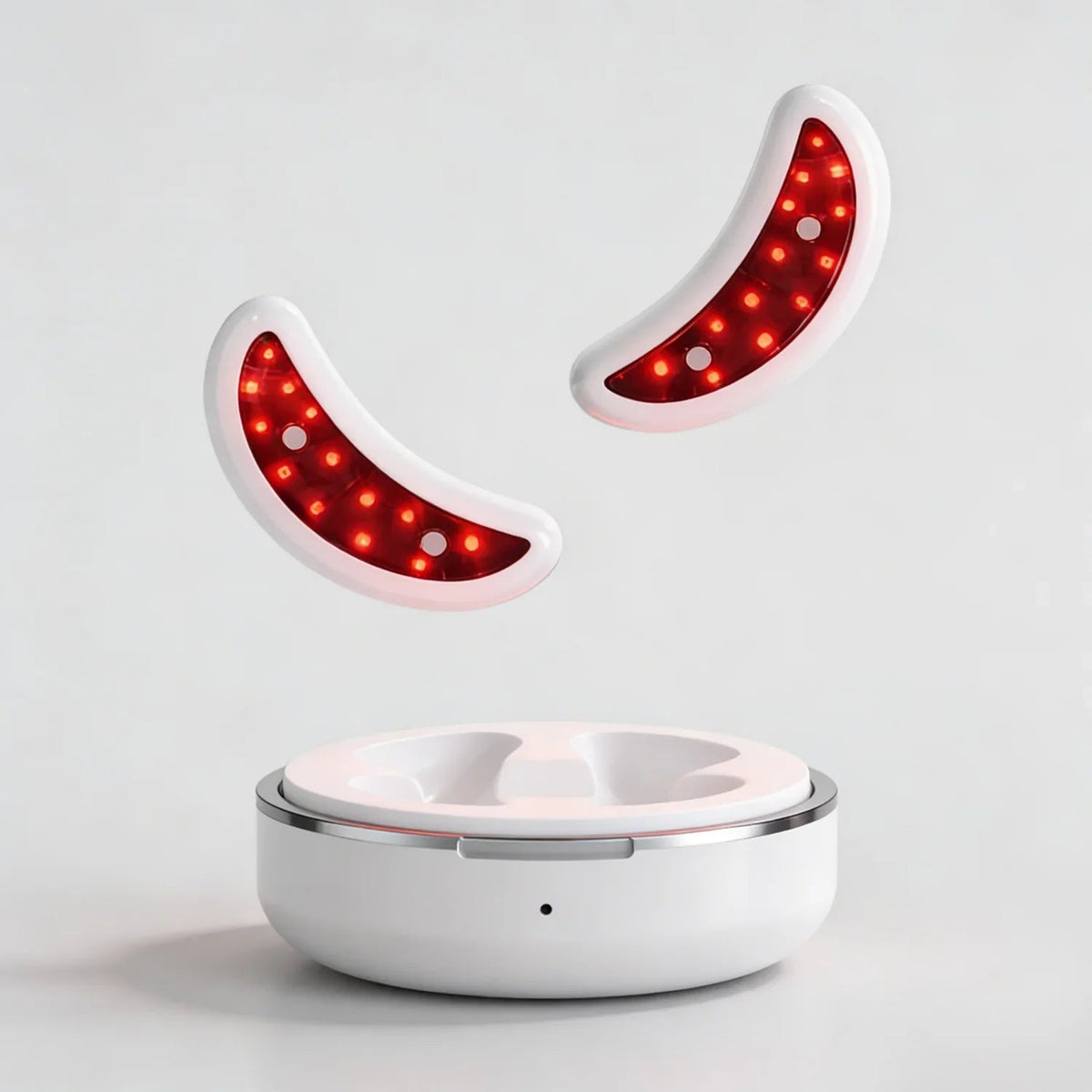 Two glowing Nicebeam Red Light Therapy Eye Pods above their round charging case