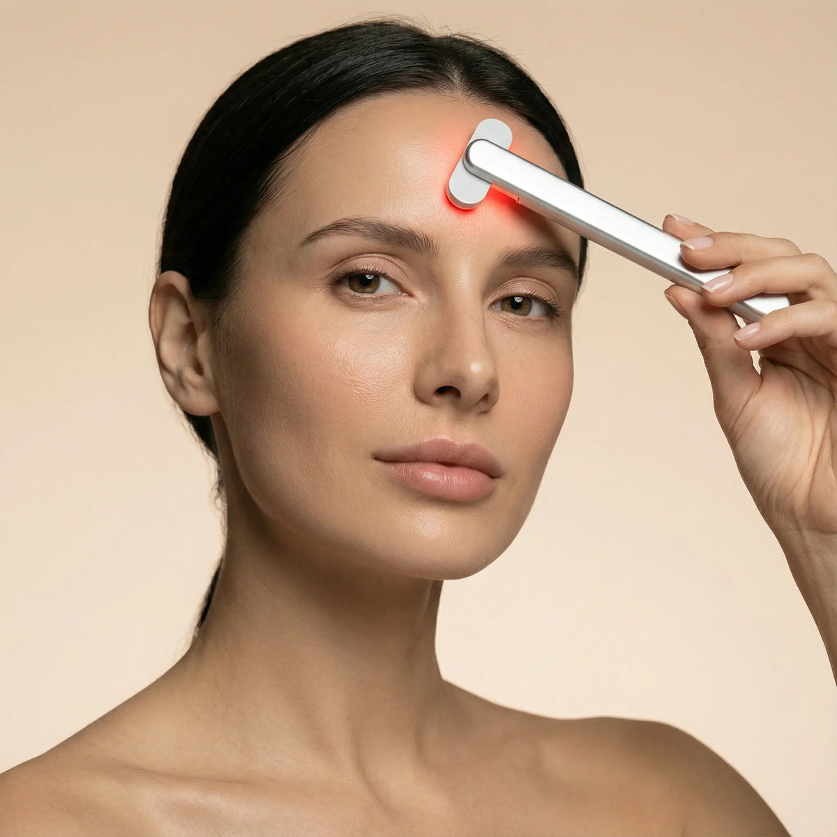 Woman using the Nicebeam 4-in-1 Skincare Wand on her forehead with red light on
