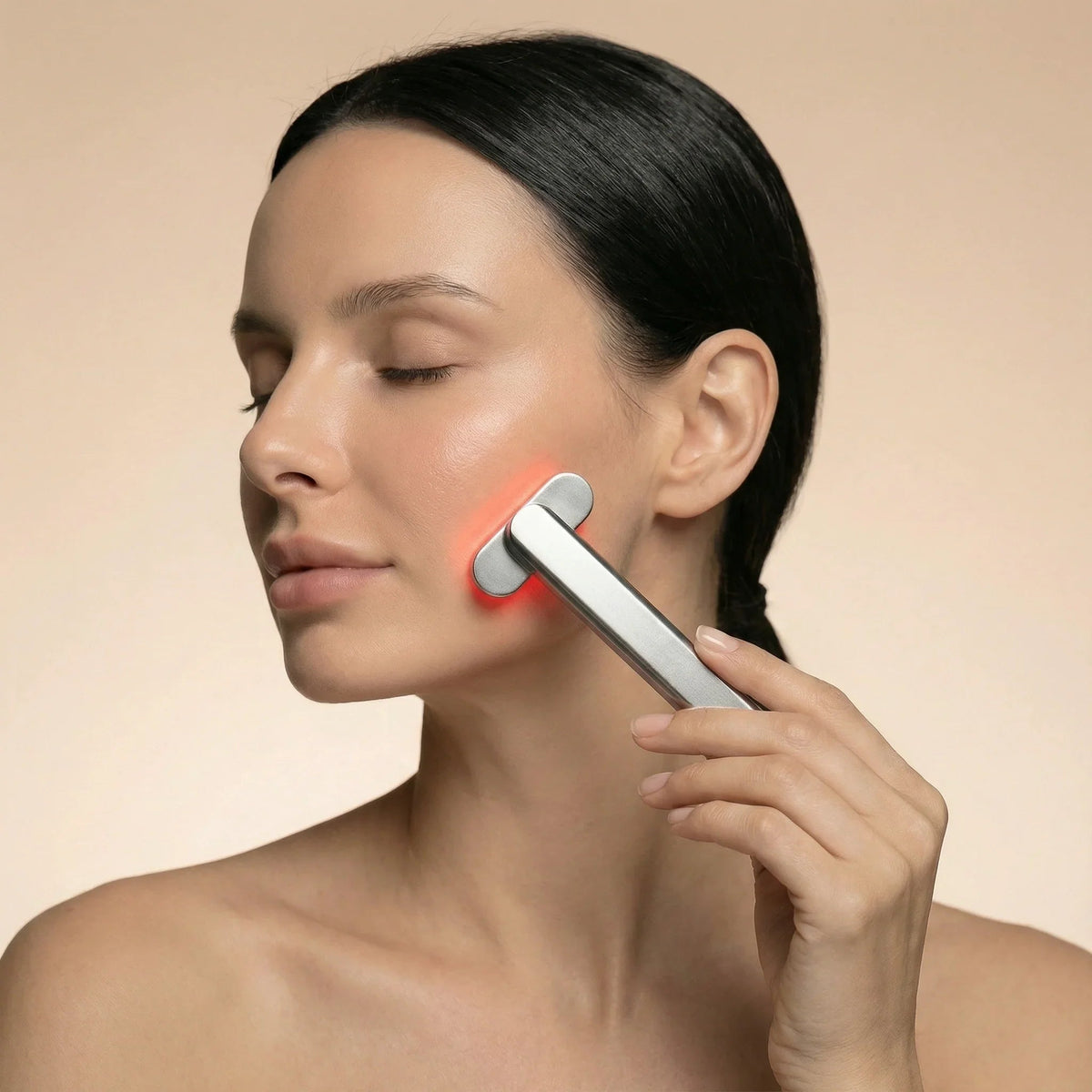 Woman with eyes closed using the Nicebeam 4-in-1 Skincare Wand on her jaw