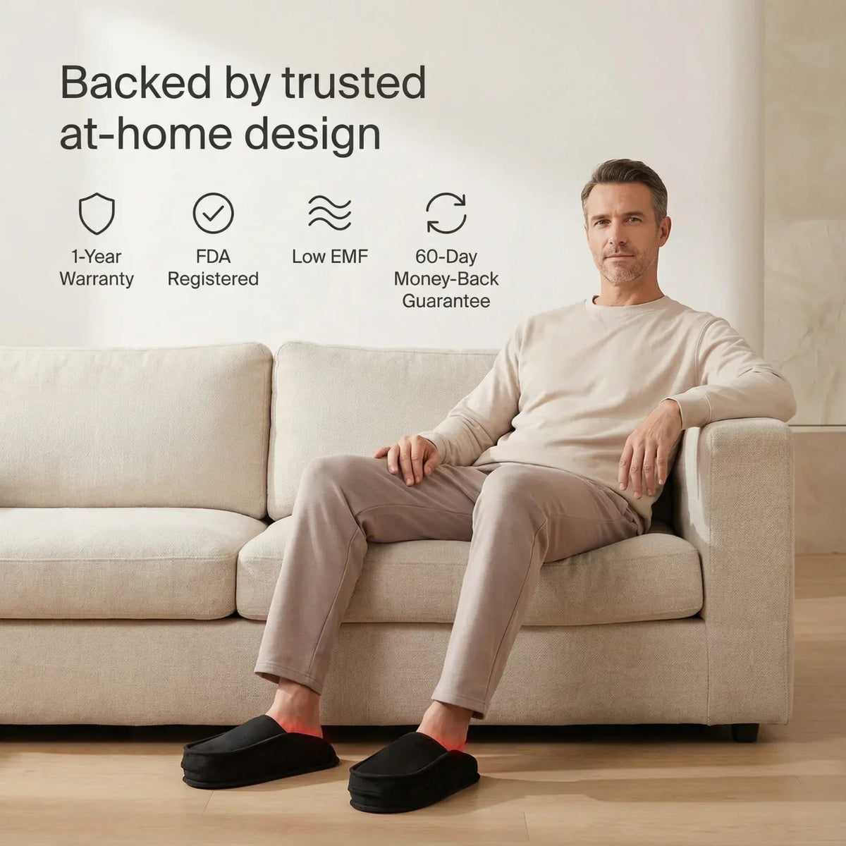 Man on a sofa wearing Nicebeam Red Light Therapy Slippers with warranty and at-home use icons