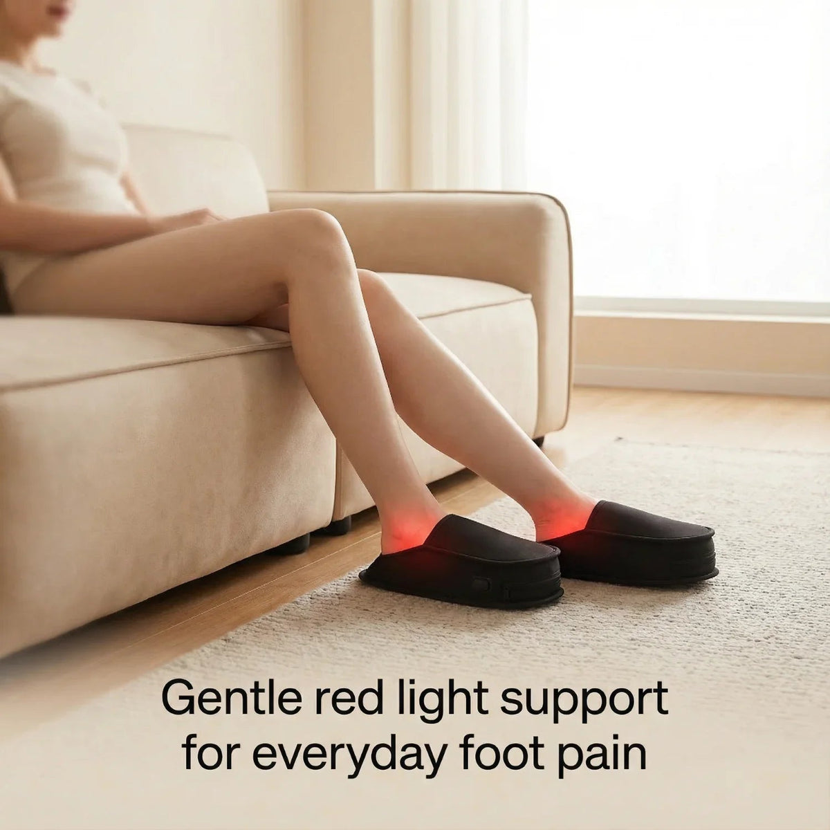 Woman on a sofa wearing Nicebeam Red Light Therapy Slippers with red light glowing