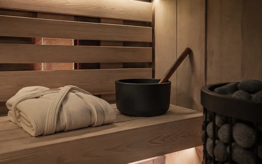 Private hybrid sauna corner with bench, robe and sauna accessories