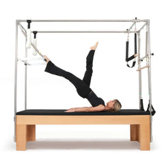 Woman performing a leg lift exercise on the black Elina Pilates Wooden Cadillac