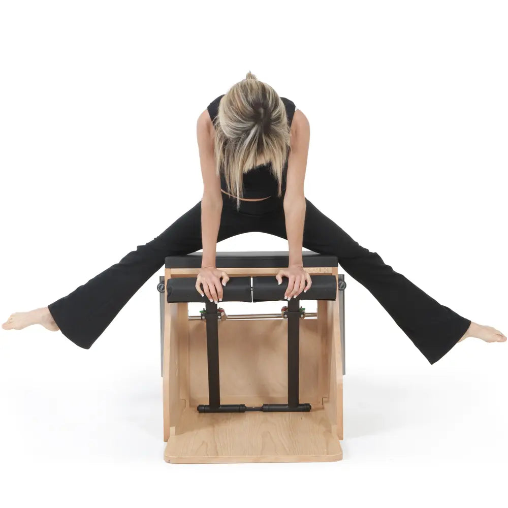 Woman using the black Elina Pilates wooden base Combo Chair in a front facing exercise