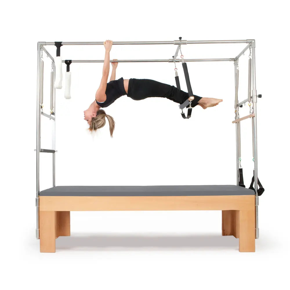 Woman performing a hanging exercise on the Elina Pilates Wooden Cadillac