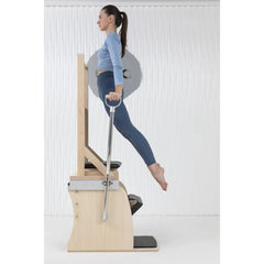 Woman performing a side leg exercise on the Elina Pilates Wunda Electric Chair