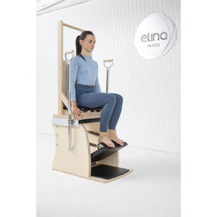 Woman performing a seated pedal exercise on the Elina Pilates Wunda Electric Chair