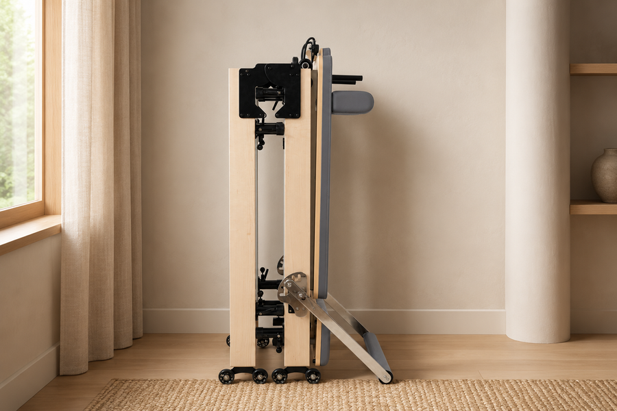 Folded wooden Pilates reformer stored upright in a home interior
