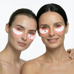 Two women wearing the Nicebeam Red Light Therapy Eye Pods under their eyes