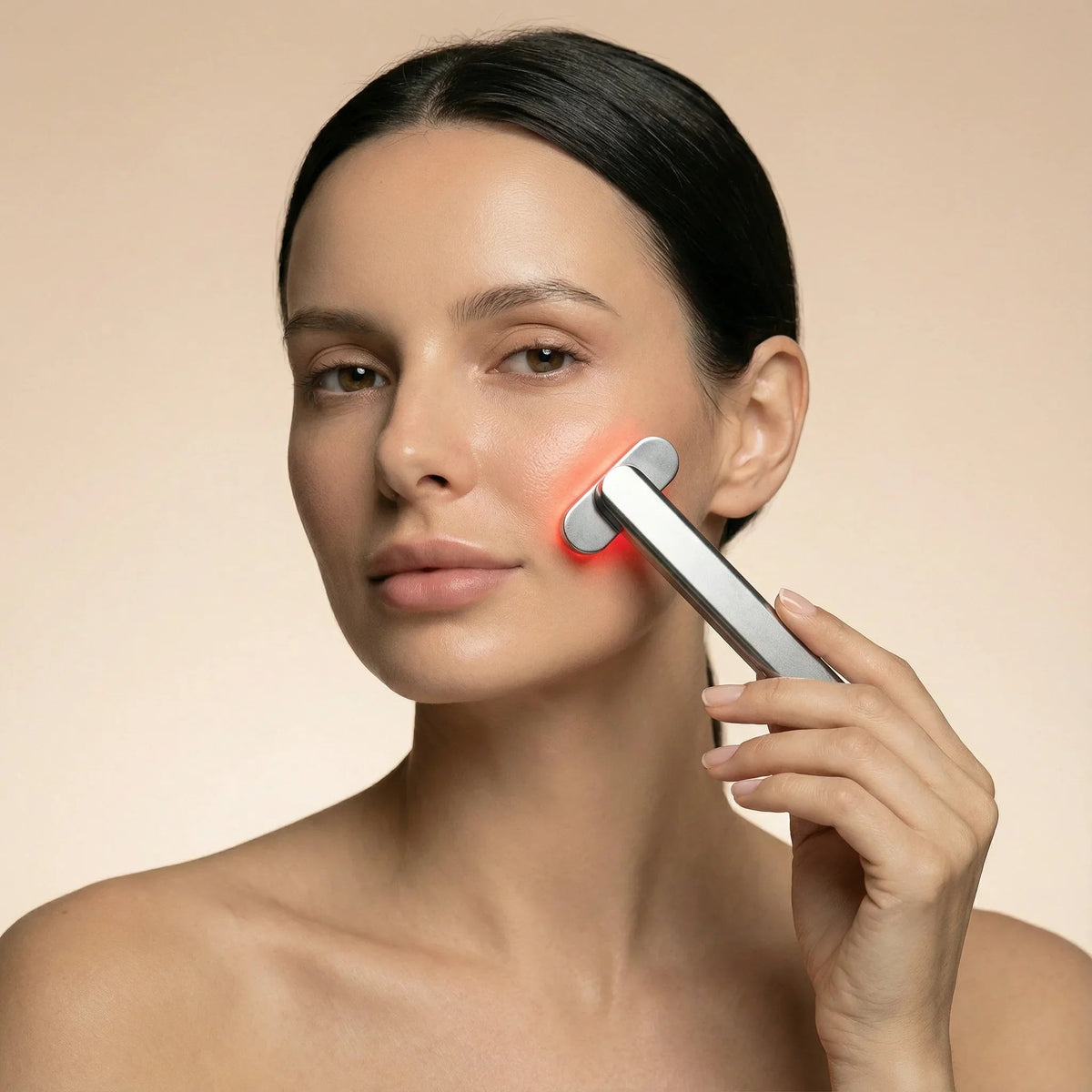 Woman gliding the Nicebeam red light therapy wand along her cheek