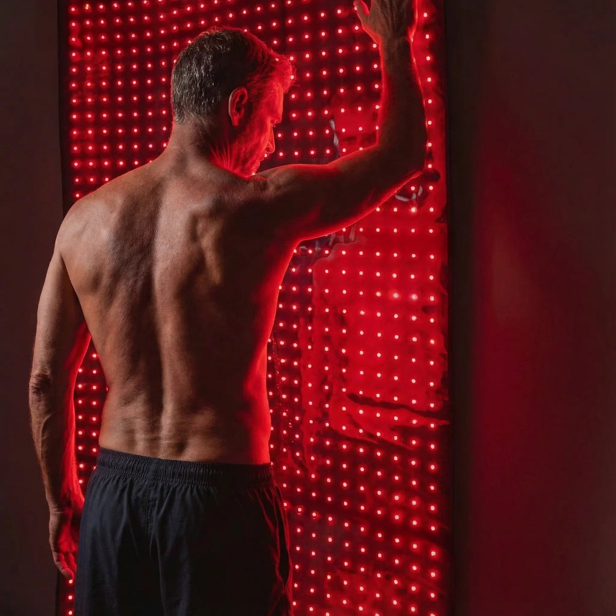 Man using the Nicebeam full body red light therapy mat across his back