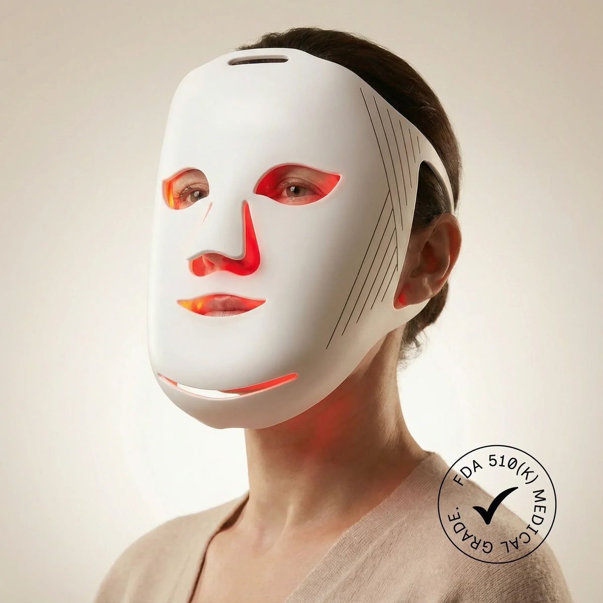 Woman wearing a white Nicebeam LED face mask illuminated with red light