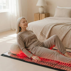 Woman reclining on the Nicebeam red light therapy mat at home
