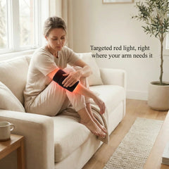 Woman on a sofa using the Nicebeam Red Light Armband on her forearm
