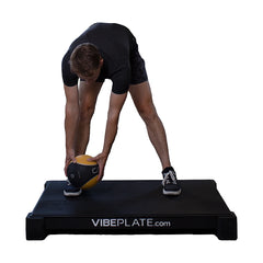 Woman performing a kettlebell forward fold on the VibePlate 3048
