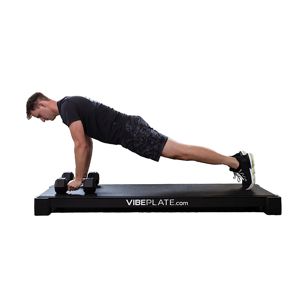Man performing a dumbbell push-up on the VibePlate XL platform