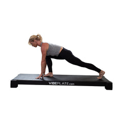 Woman performing a lunge on the YogaPlate vibration platform